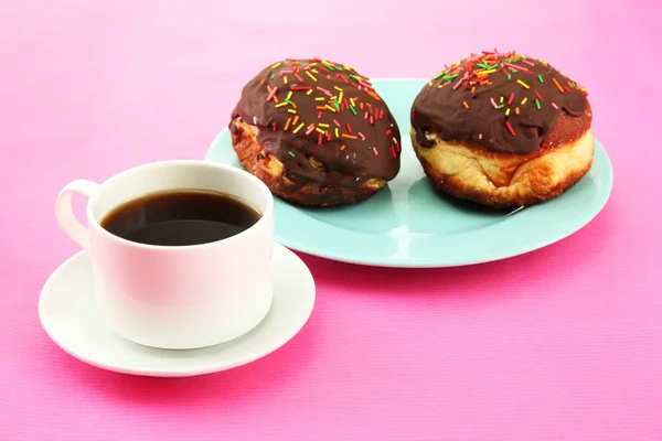 Вкусные пончики на цветовой пластине на цветном фоне — стоковое фото