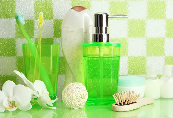 Bath accessories on shelf in bathroom on green tile wall background — Stock Photo, Image