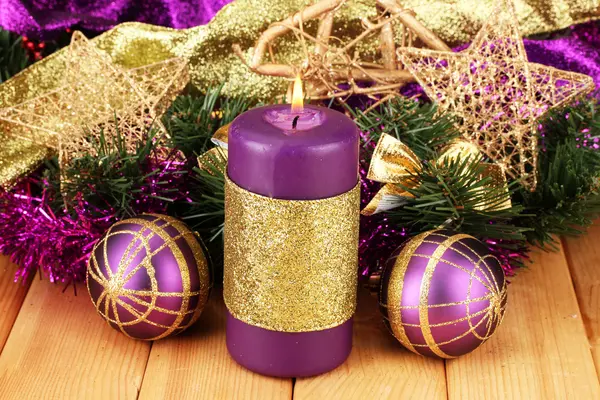 Christmas composition with candles and decorations in purple and gold colors on wooden background — Stock Photo, Image