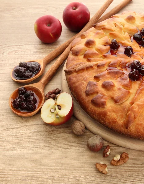 Вкусный домашний пирог с джемом и яблоками, на деревянном столе — стоковое фото