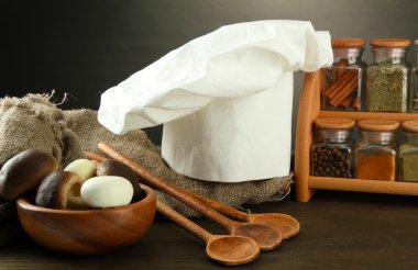 Şef'in şapkası ve kitchenwear tabloda gri arka plan üzerinde kompozisyonu