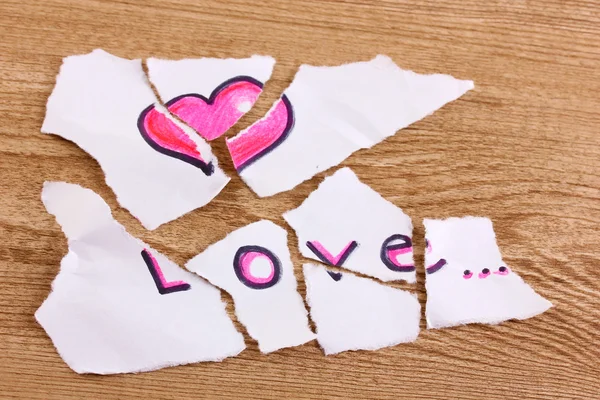 Torn paper with words Love close-up on wooden table — Stock Photo, Image