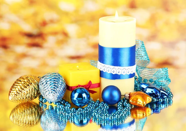 Yellow candle with christmas decoration on bright background — Stock Photo, Image