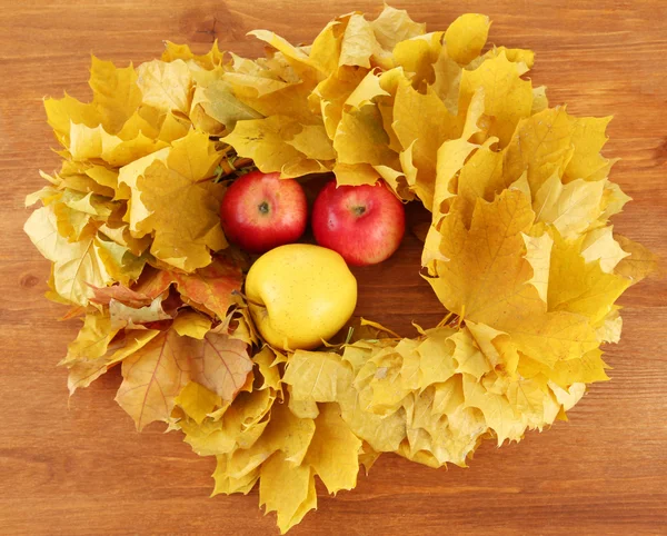Composição outonal com folhas amarelas, maçãs sobre fundo de madeira — Fotografia de Stock