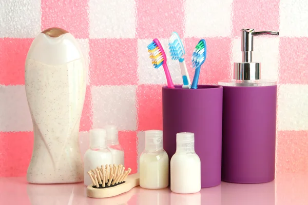 Bath accessories on shelf in bathroom on pink tile wall background — Stock Photo, Image