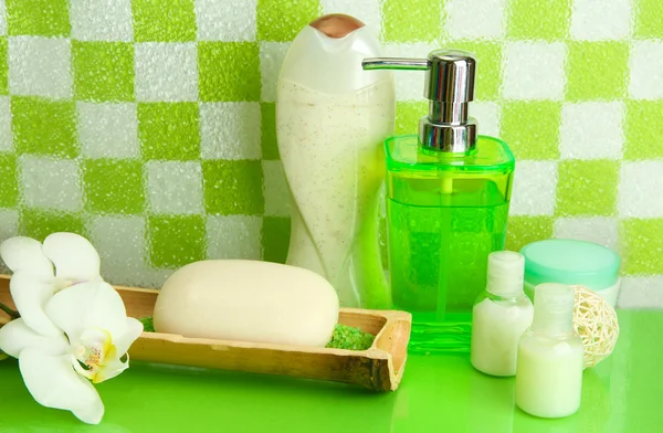 Accesorios de baño en el estante en el baño sobre fondo de pared de baldosas verdes —  Fotos de Stock