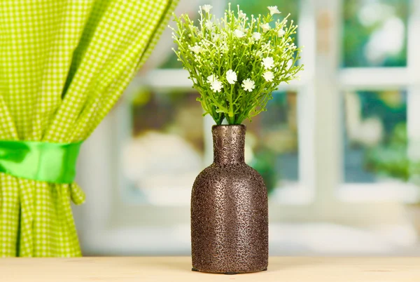 Dekoratív virágok vázában ablakpárkányon — Stock Fotó
