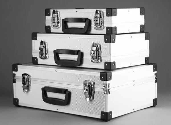 Серебристые чемоданы на сером фоне — стоковое фото