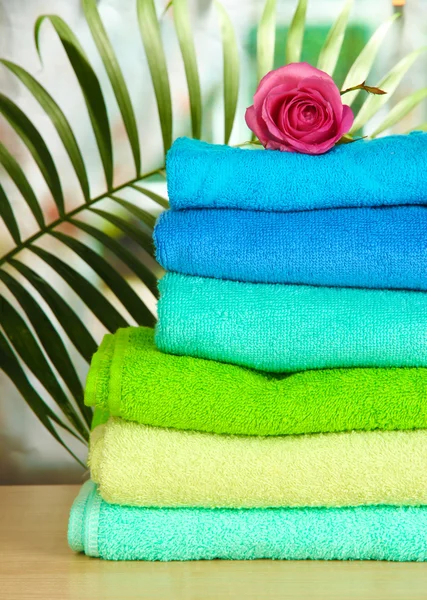 Stack of towels with fragrant flower on window background — Stock Photo, Image