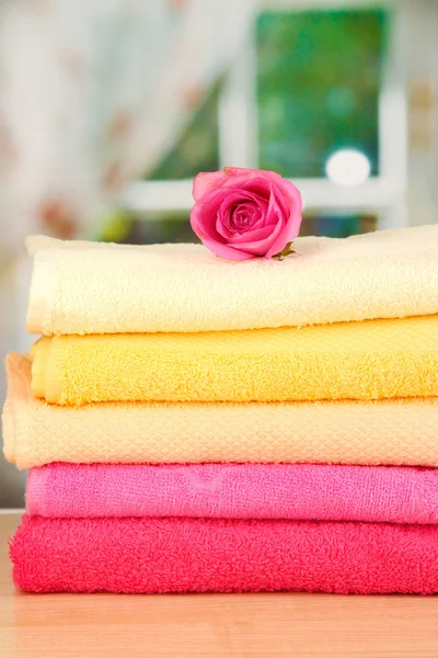 Στοίβα πετσέτες με αρωματικά λουλούδια σε φόντο παράθυρο — Φωτογραφία Αρχείου