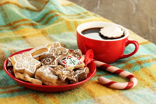 Weihnachtsleckereien auf Teller und Tasse Kaffee in karierter Nahaufnahme — Stockfoto