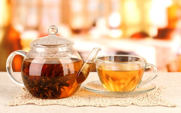 Exotic green tea with flowers in glass teapot on bright background — Stock Photo, Image