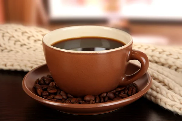 Taza de café con bufanda en la mesa en la habitación —  Fotos de Stock