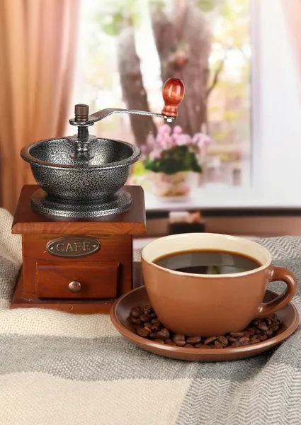 Cup of coffee with scarf and coffee mill on table in room — Stock Photo, Image