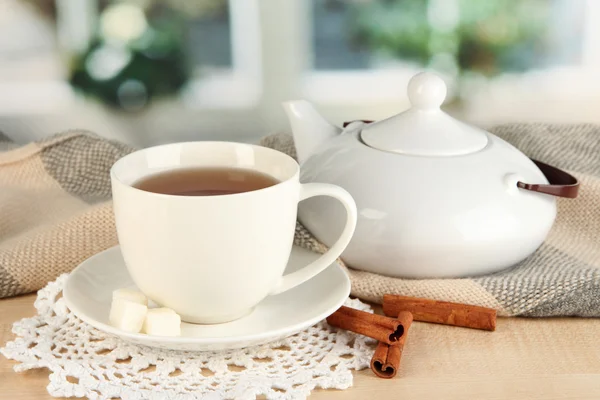 Cup of tea with scarf on table in room — Stock Photo, Image