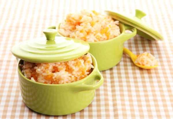 Taste rice porridge with pumpkin in saucepans on tablecloth background — Stock Photo, Image