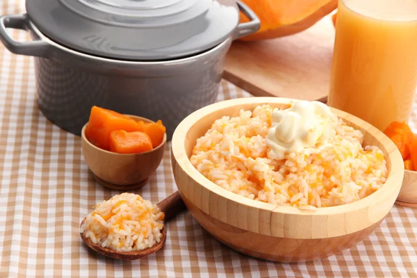 Prove mingau de arroz com abóbora e copo de suco no fundo de toalha de mesa — Fotografia de Stock