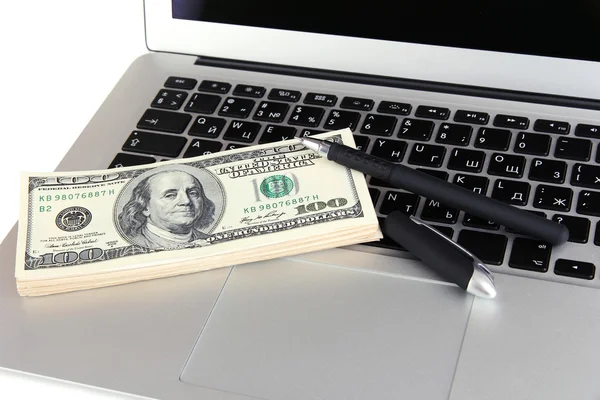 Geld met pen op laptop close-up — Stockfoto