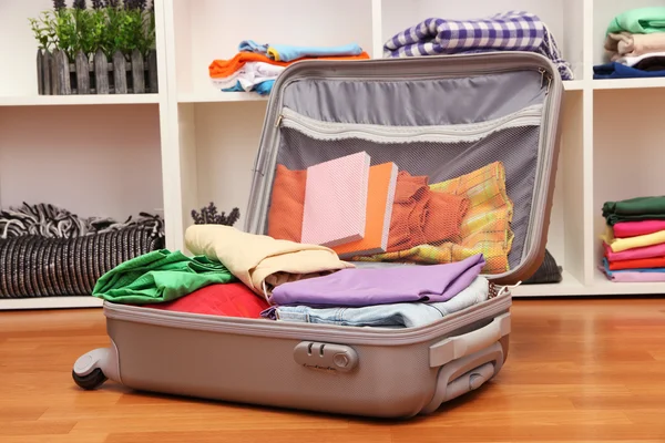 Valise ouverte grise avec vêtements dans la chambre — Photo