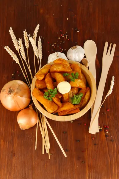 Appetizing village potatoes in bowl on wooden table close-up — Stock Photo, Image