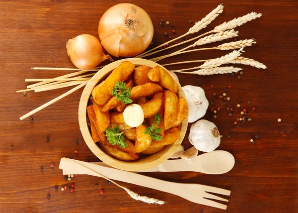 Appetizing village potatoes in bowl on wooden table close-up — Stock Photo, Image
