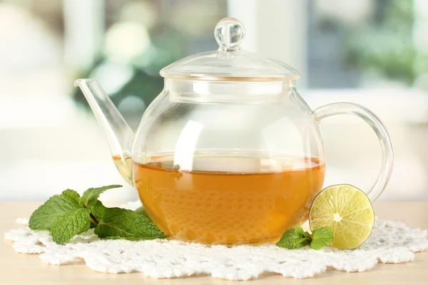 Teapot with mint and lime on table in room — Stock Photo, Image