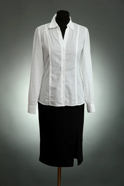 Białą bluzkę i czarną spódnicę na manekin na szarym tle — Zdjęcie stockowe