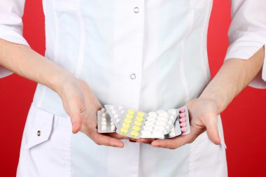 kadın doktor el hapları, renkli arka plan üzerinde tutarak yakın çekim