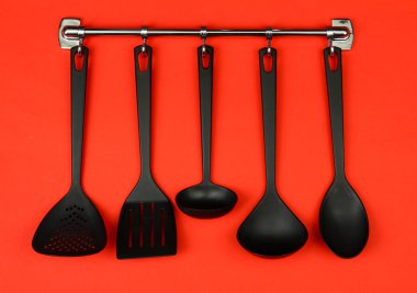 Gümüş kanca, kırmızı zemin üzerine siyah mutfak gereçleri