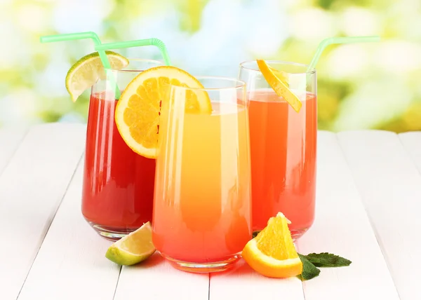 Three cocktails on wooden table on bright background — Stock Photo, Image