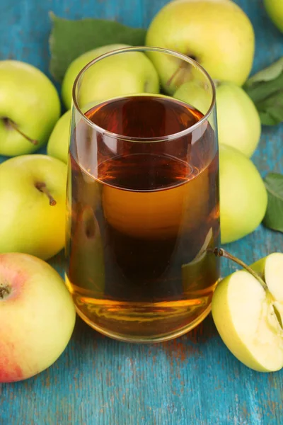 Användbara äppeljuice med äpplen runt på träbord — Stockfoto