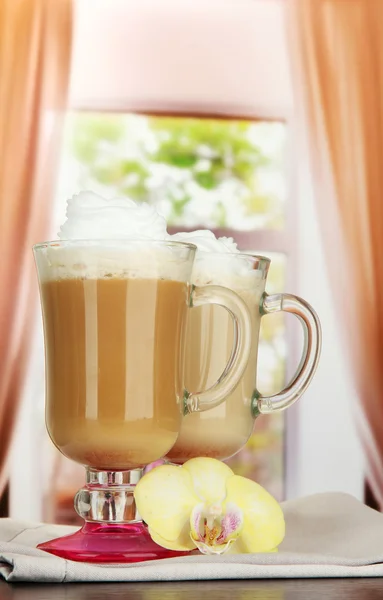 Latte de café perfumado em copos copos com vagens de baunilha, na mesa no café — Fotografia de Stock