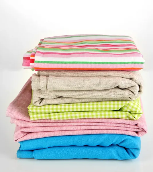 Pile of different fabrics isolated on white — Stock Photo, Image