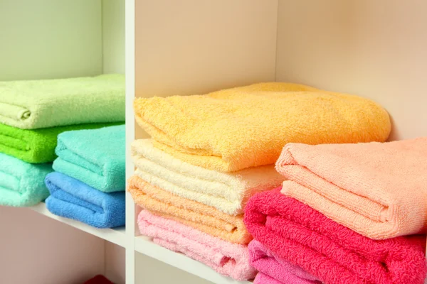 Färgglada handdukar på hyllor i badrummet — Stockfoto