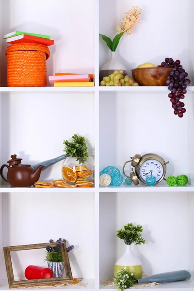 Beautiful white shelves with scattered different home related objects — Stock Photo, Image