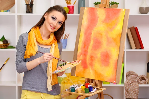 Mooie jonge vrouw schilder op het werk, op kamer interieur achtergrond — Stockfoto