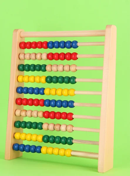 Lichte houten speelgoed abacus, op groene achtergrond — Stockfoto