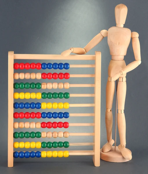 Heldere speelgoed abacus en houten pop, op grijze achtergrond — Stockfoto