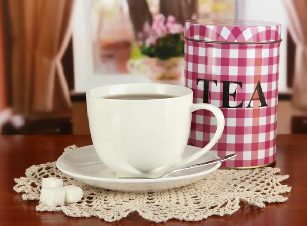 Tarro y taza de té en la mesa en la habitación —  Fotos de Stock