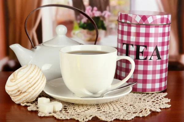Tarro y taza de té en la mesa en la habitación — Foto de Stock