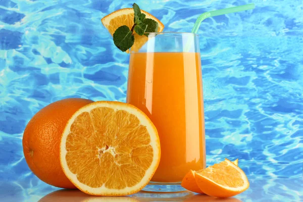 Glass of orange juice with mint and orange on sea background — Stock Photo, Image