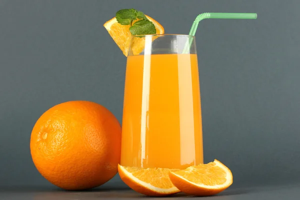 Glass of orange juice with mint and orange on grey background — Stock Photo, Image