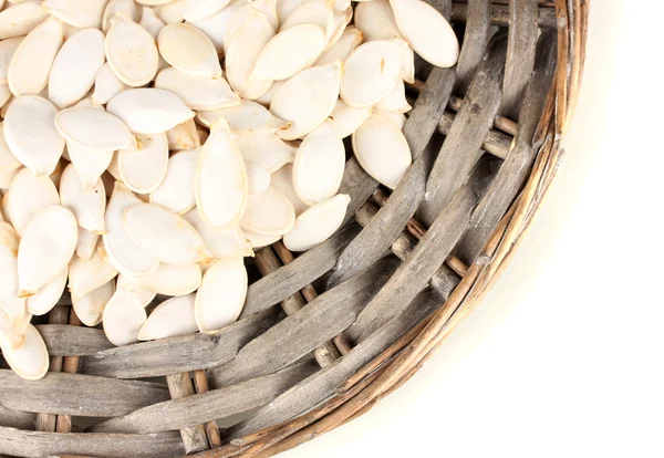 Pumpkin seeds on wicker mat, isolated on the white — Stock Photo, Image