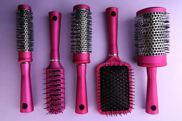 Comb brushes on purple background — Stock Photo, Image