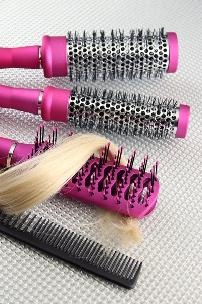 Escovas de pente com cabelo, sobre fundo cinza — Fotografia de Stock