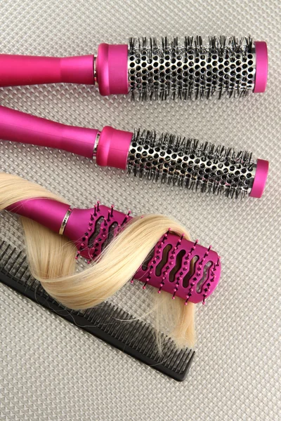 Spazzole pettinabili con capelli, su fondo grigio — Foto Stock