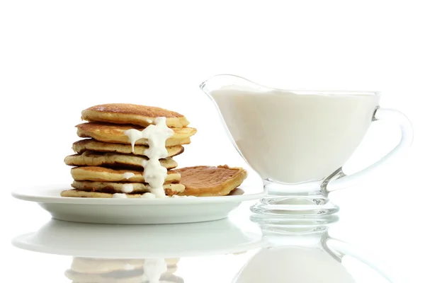 Zoete pannenkoeken op plaat met gecondenseerde melk geïsoleerd op wit — Stockfoto