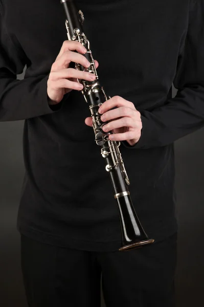 Músico tocando no clarinete no fundo preto — Fotografia de Stock