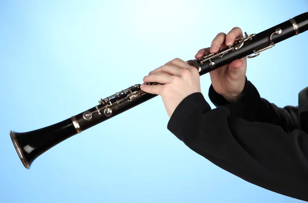 Musicista che suona il clarinetto su sfondo blu — Foto Stock