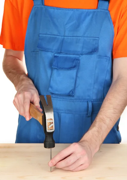 Builder hammering nails into board isolated on white — Stock Photo, Image